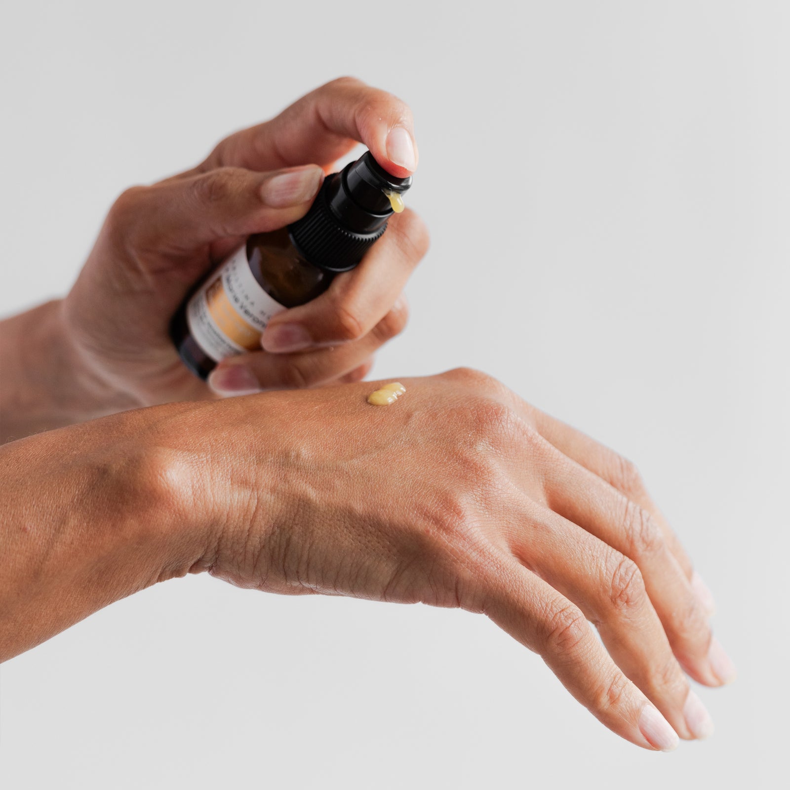 Hand using pump to show texture of Marie Veronique C-Therapy Serum 1 oz / 30 ml. VIT-C for sensitive/symptomatic/aging skin. New/genius C derivatives deliver nourishment, clear + brighten.