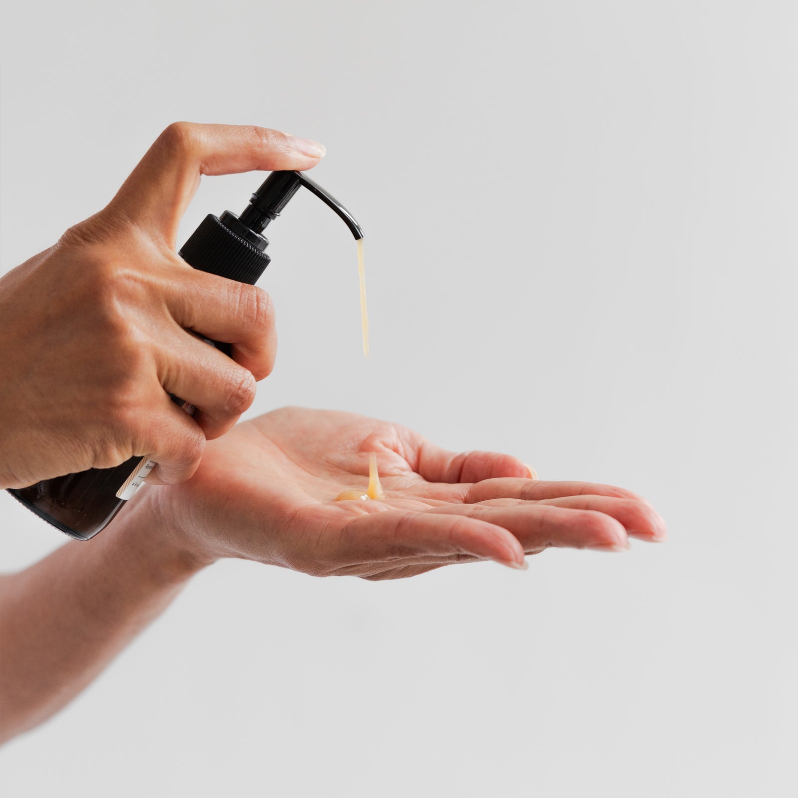 Hand pumping cleanser into hand to see texture of Marie Veronique Pure + E.O. Free Oil Cleanser 4 fl oz / 120 ml. Non-stripping, to gently resurface and smooth skin with OMEGA-6 OILS+SOD. Removes sunscreen and makeup. Microbiome-friendly Fragrance + Essential Oil free