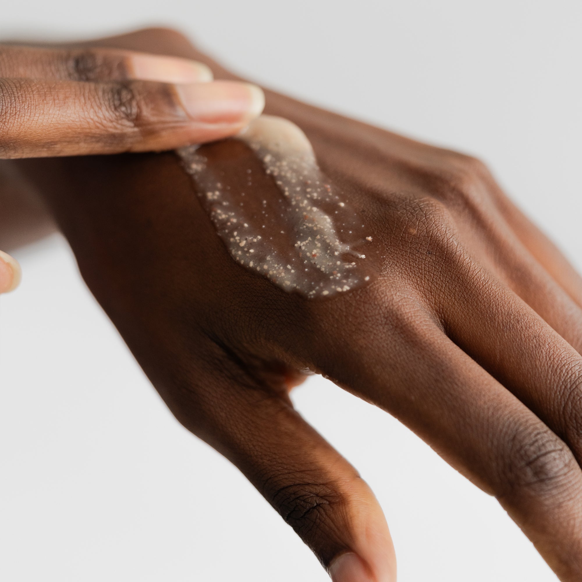 Hand rubbing product showing texture of Marie Veronique Daily Exfoliating Cleanser 4 fl oz / 118 ml. A gentle cleanser formulated with alpha and beta hydroxy acids and adzuki bean powder for dissolving and removing dead skin cells without risk of microtears.